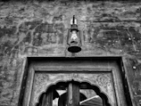 Close-up of antique lanterns hanging in the stone hallway of the gîte.