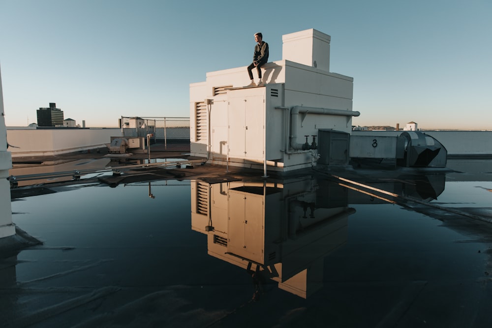 man sits on top of building