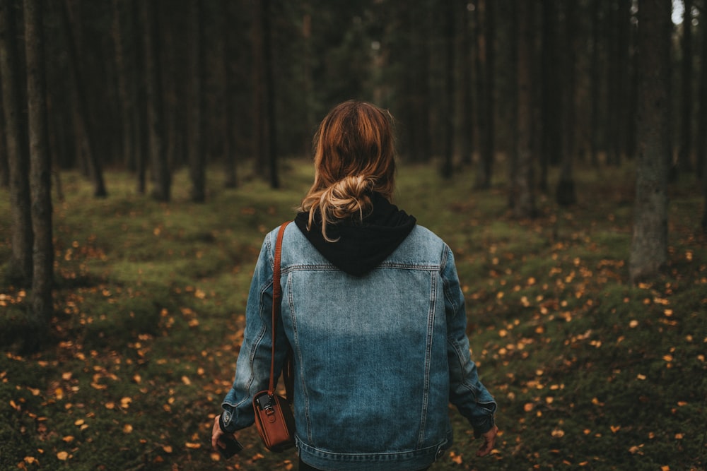 woman wearing blue denim jeans surrounded by trees