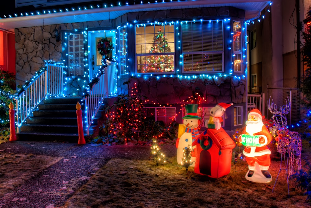 Schneemann und Weihnachtsmann in der Nähe von Hausdekoration