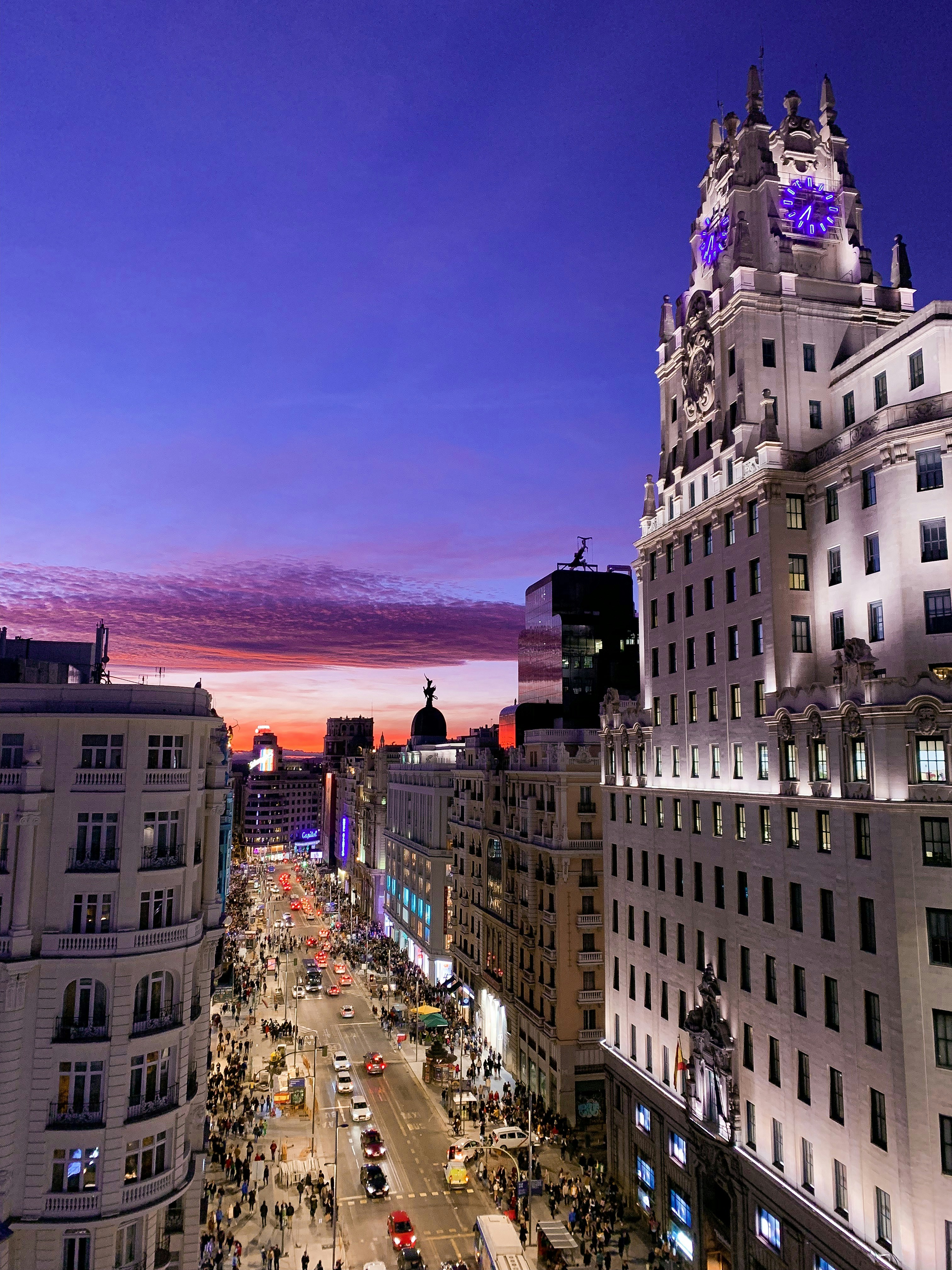 Lively Gran Via in Madrid, Spain, at sunset, with colourful clouds and sky.