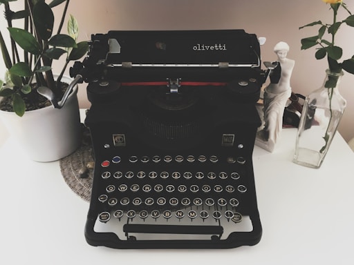 Elegant vintage typewriter with a Premio Verga letter on a wooden desk.