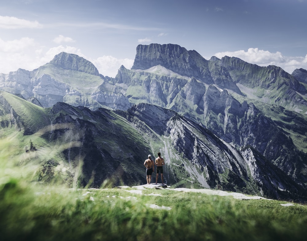 two men standing on rock during daytime