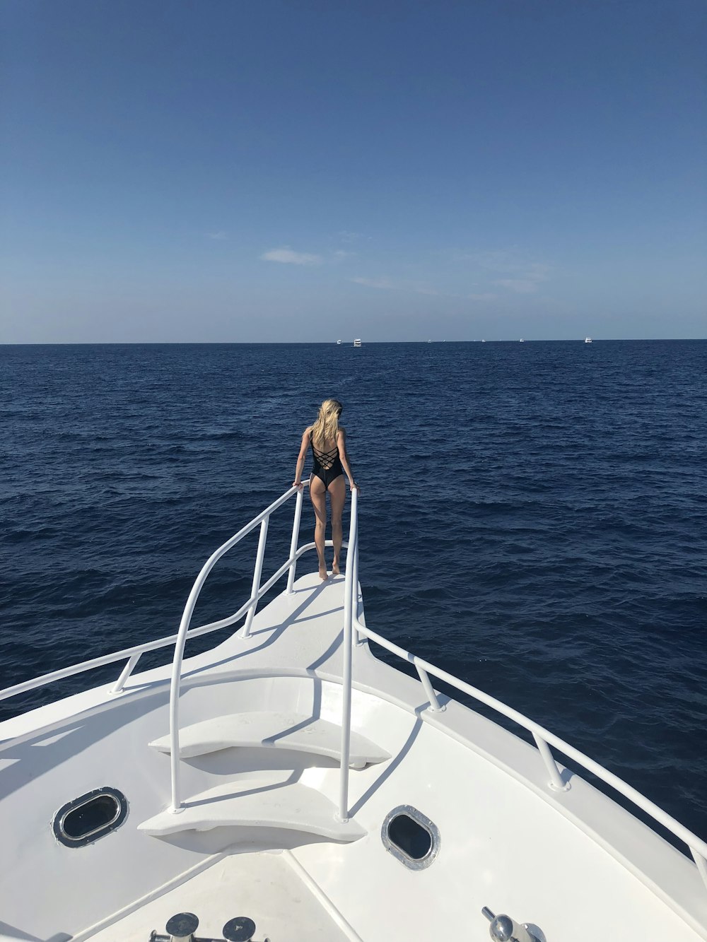 woman standing in front of white boat