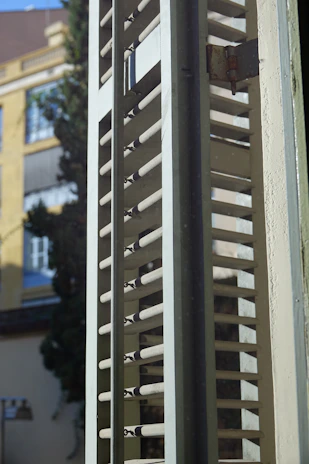 Close-up of a sleek dark luxury louvered shutter with subtle texture under soft lighting