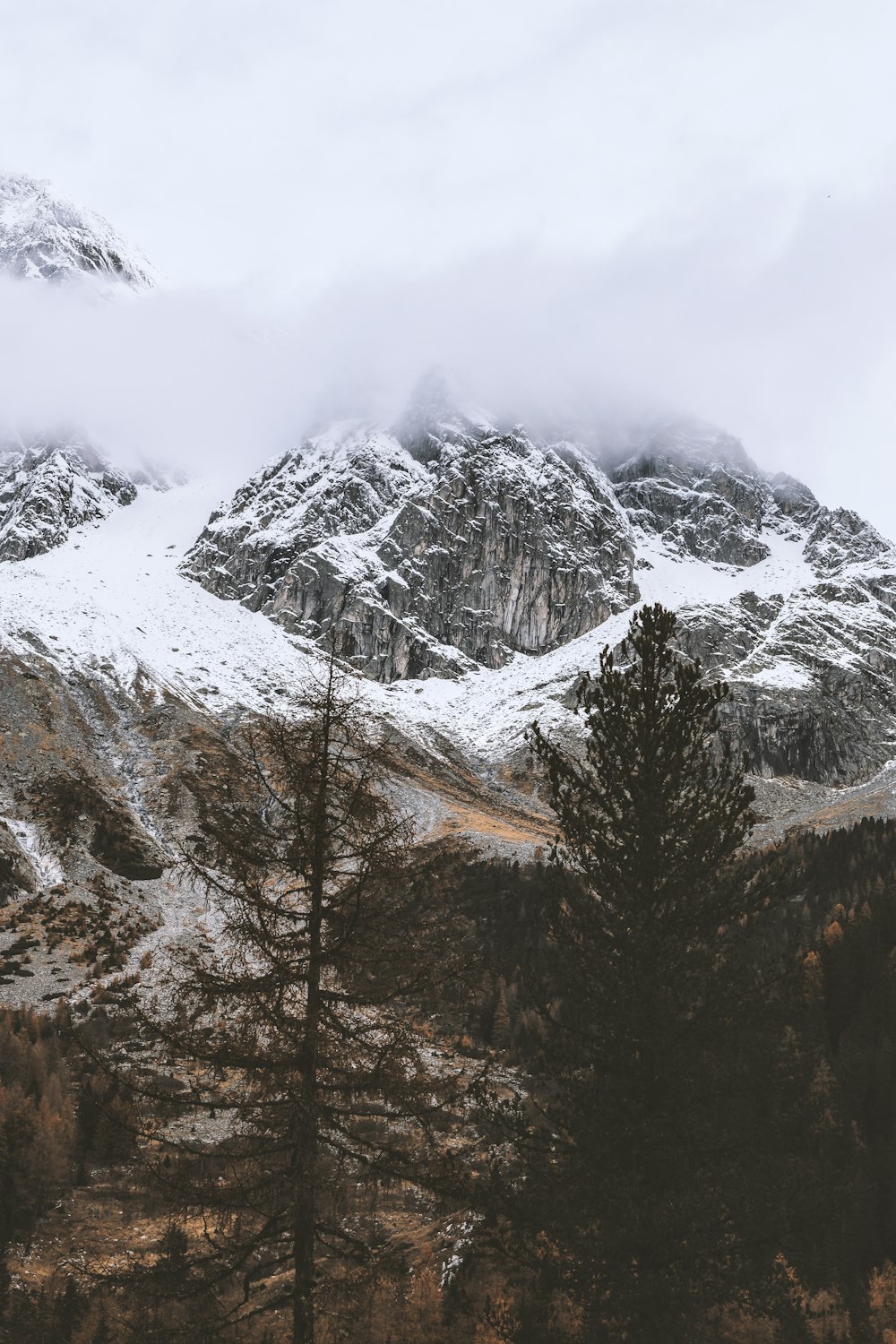 snow capped rocky mountain under cloudy sky