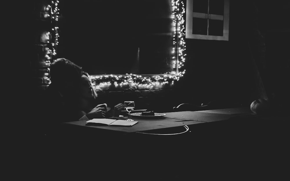 une personne assise à une table devant un miroir