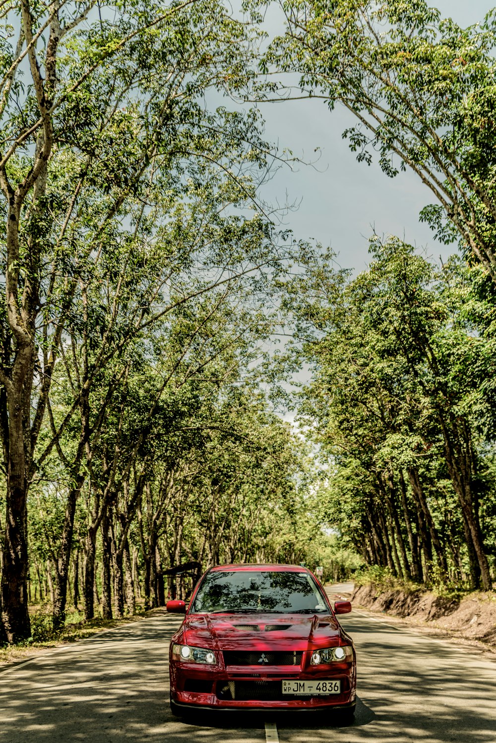 red Mitsubishi vehicle under blue sky during daytime