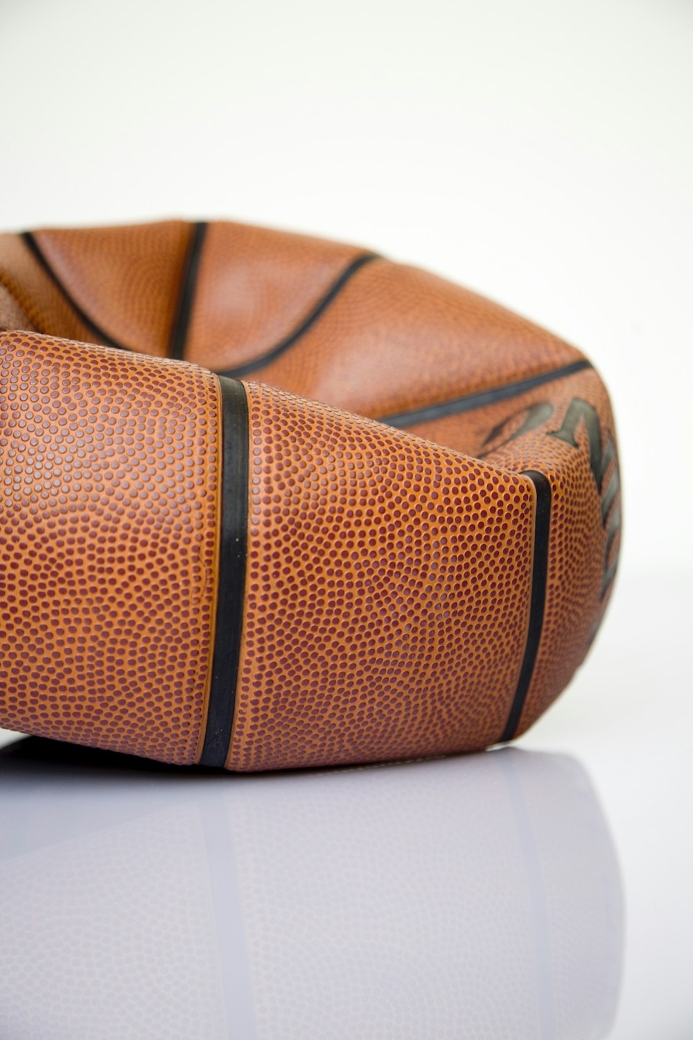 Pelota de baloncesto marrón sobre superficie blanca