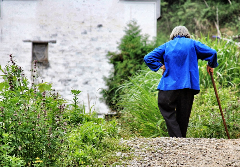 woman walking while holding walking cane