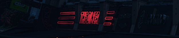 A series of neon signs are displayed on a building exterior, primarily featuring bold red lettering. The signs include text and geometric shapes, illuminated against a dark background, suggesting a nighttime urban setting.