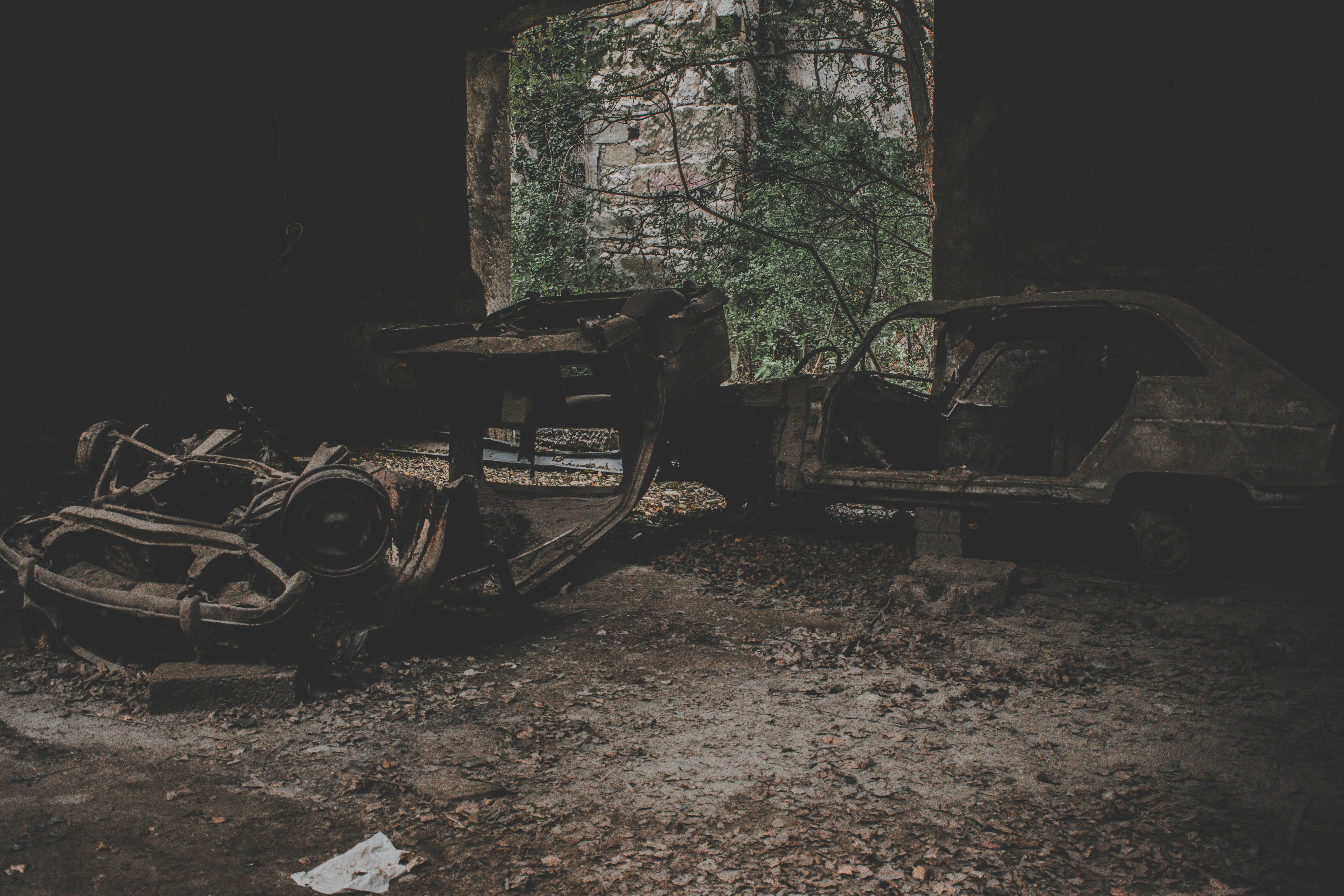 two gray wrecked vehicles inside room
