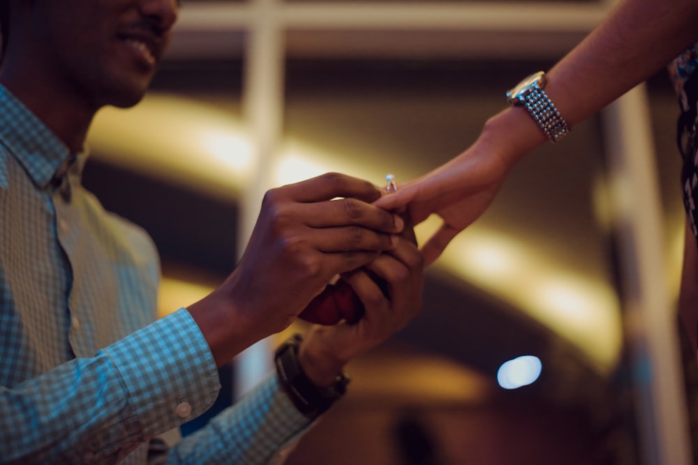 uomo che mette l'anello sulla mano della donna