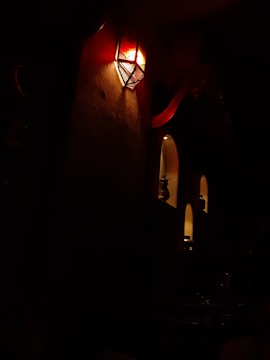 Close-up of decorative metal wall sconces casting soft light in a cozy hotel lobby.