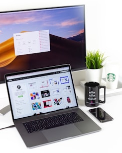 laptop near mug and computer monitor
