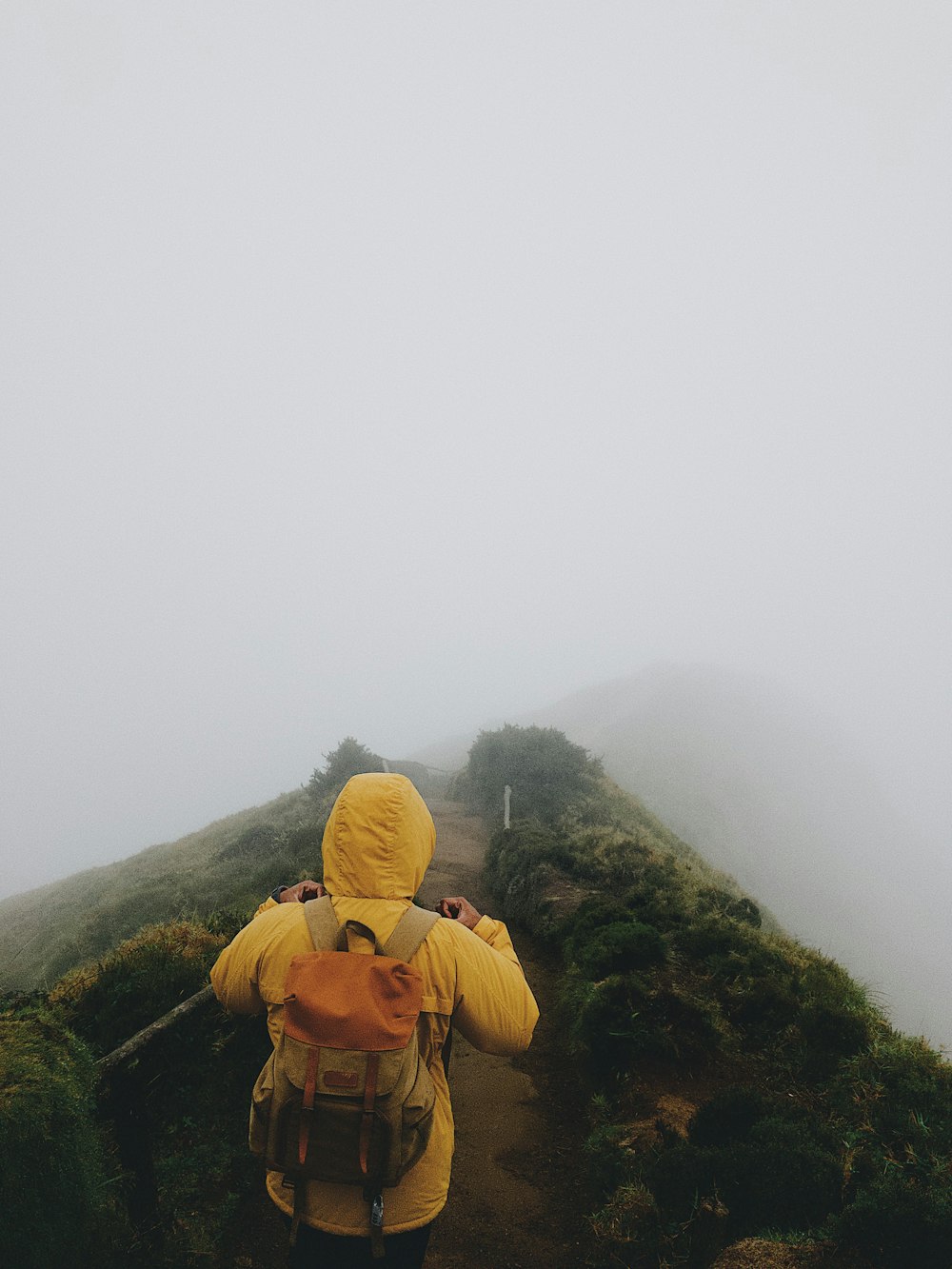 person in yellow coat wearing backpack