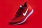 unpaired red Nike sneaker