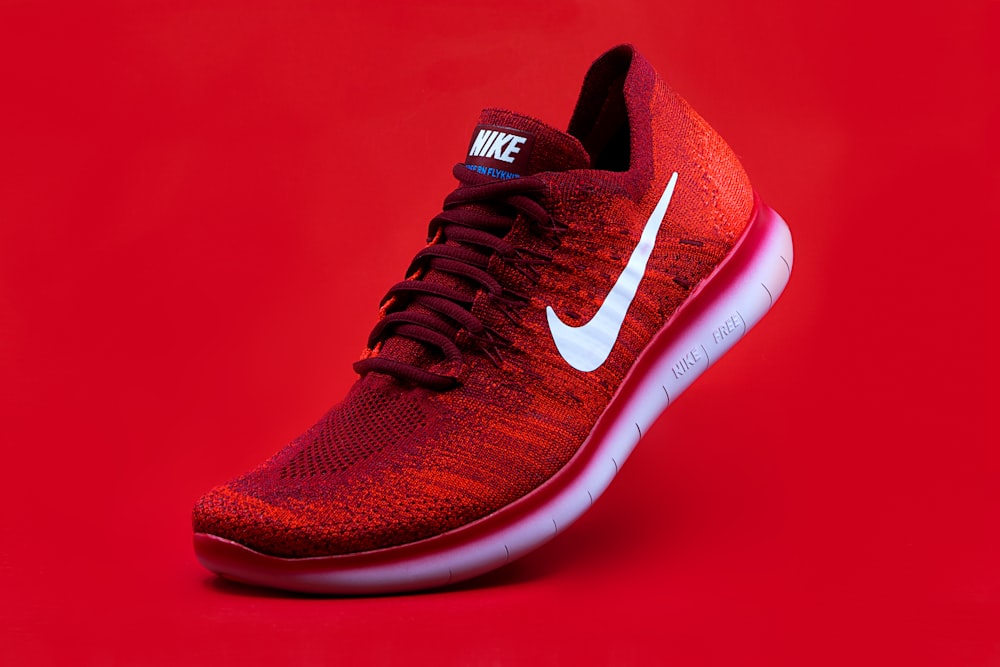 unpaired red Nike sneaker