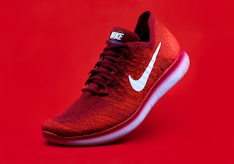 unpaired red Nike sneaker