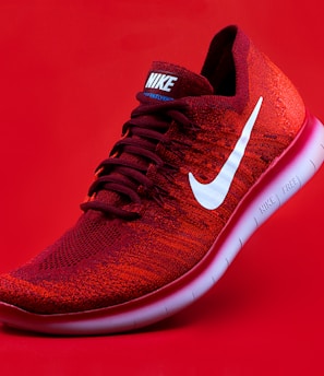 unpaired red Nike sneaker