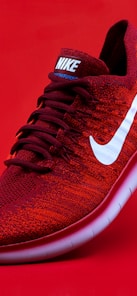 unpaired red Nike sneaker