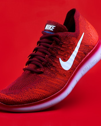 unpaired red Nike sneaker