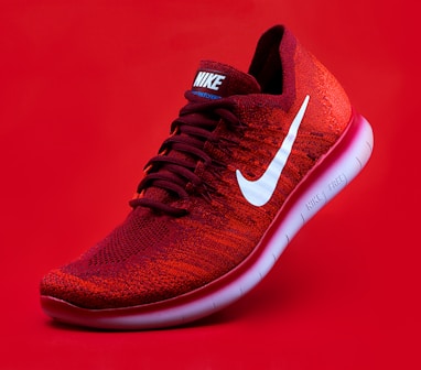 unpaired red Nike sneaker