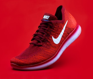 unpaired red Nike sneaker