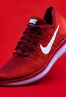 unpaired red Nike sneaker