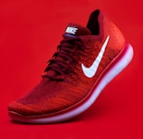 unpaired red Nike sneaker