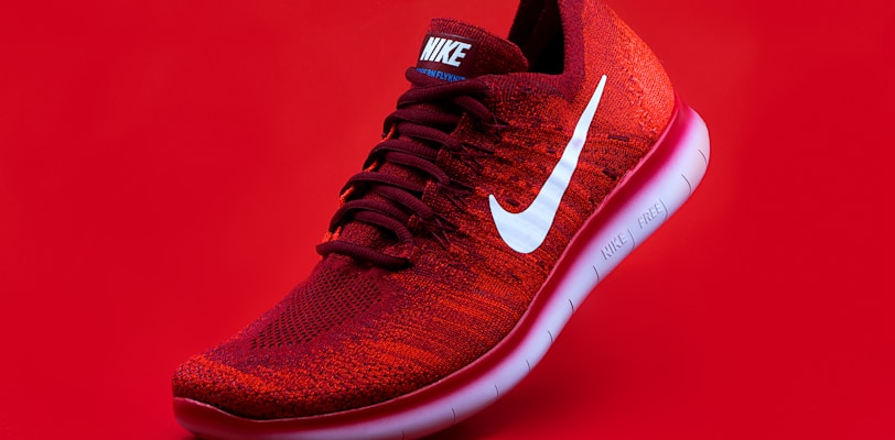 unpaired red Nike sneaker