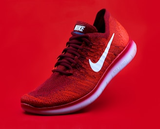 unpaired red Nike sneaker