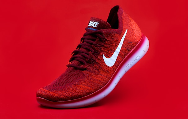 unpaired red Nike sneaker