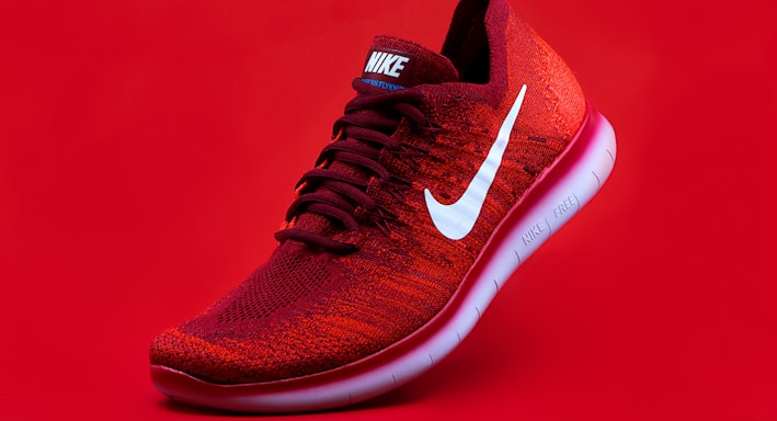 unpaired red Nike sneaker