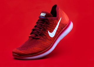 unpaired red Nike sneaker