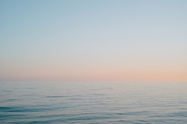 A serene ocean horizon at sunset, symbolizing the vastness of history and imagination.