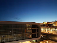 An aerial view of Paris Charles de Gaulle airport at dusk, with soft golden lighting highlighting the terminals.