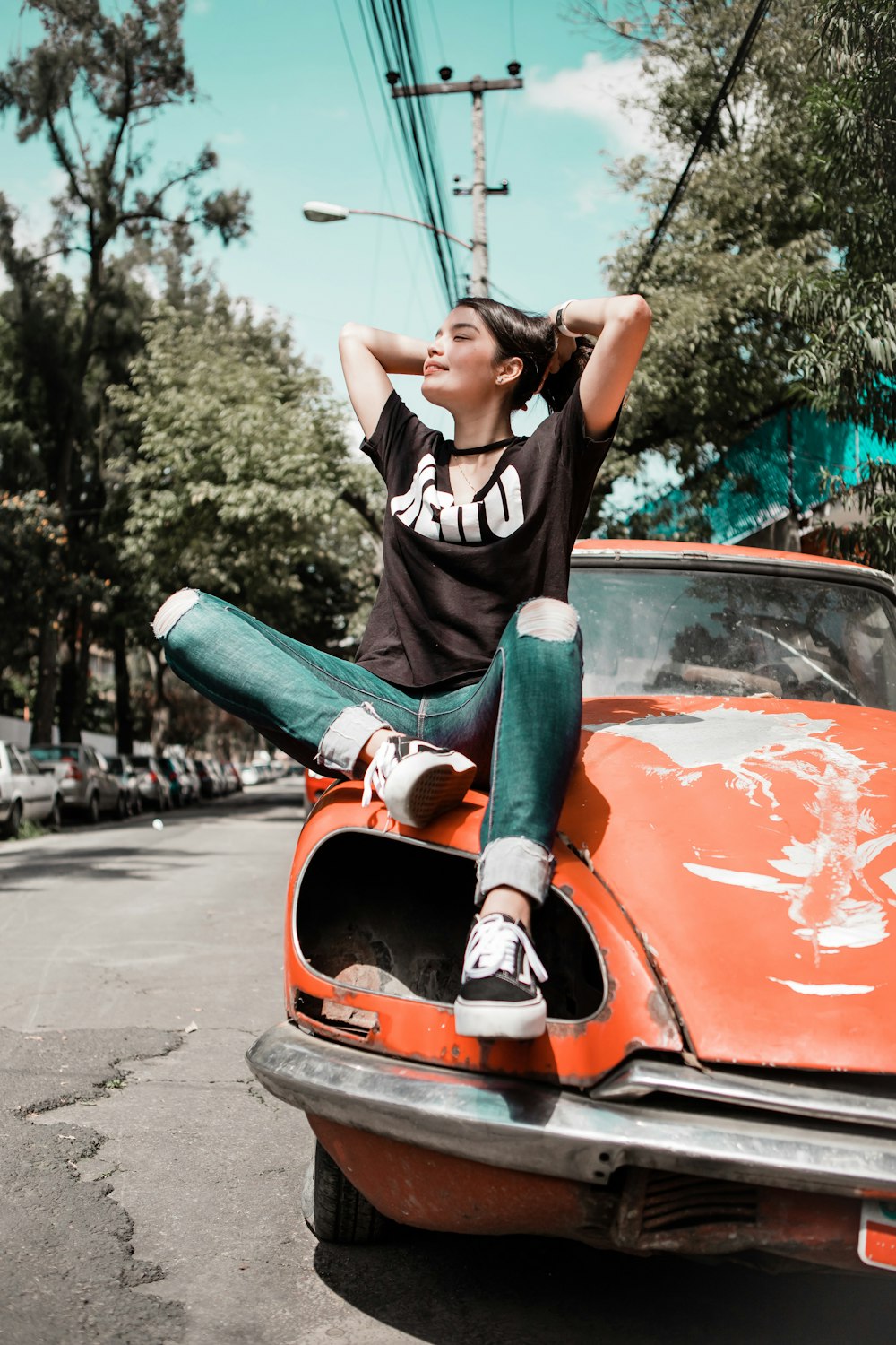 woman wearing black shirt sitting on orange vehicle