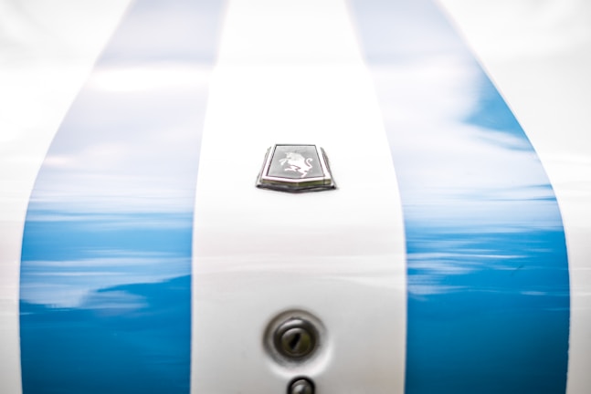 Close-up of a sleek car hood with custom paint and decals.