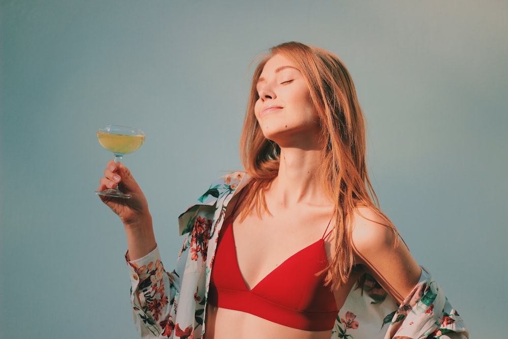 shallow focus photo of woman in red bikini top holding champagne glass