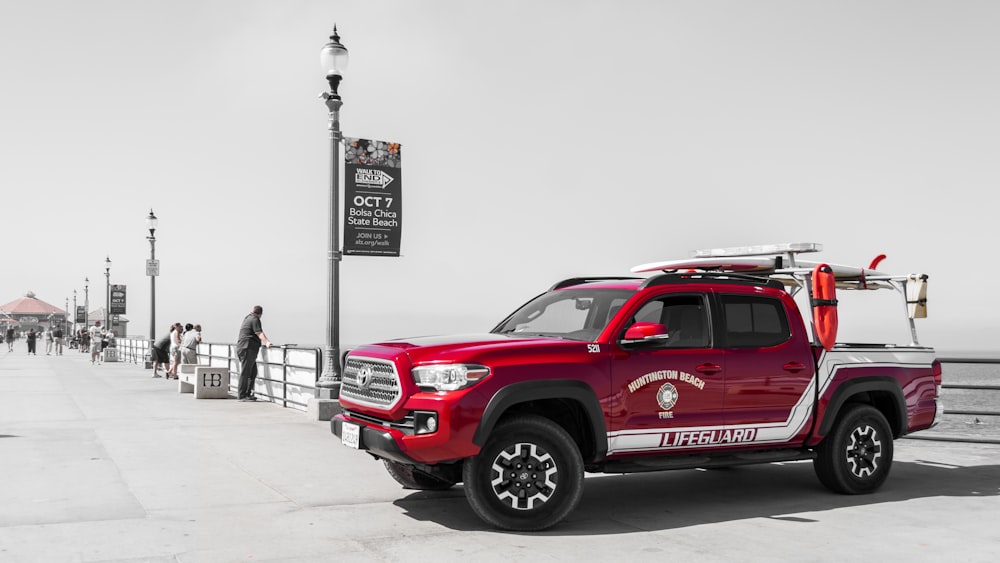 red Toyota crew-cab pickup truck parked on dockside