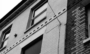 Close-up of a thermal camera screen displaying heat patterns on a building facade.