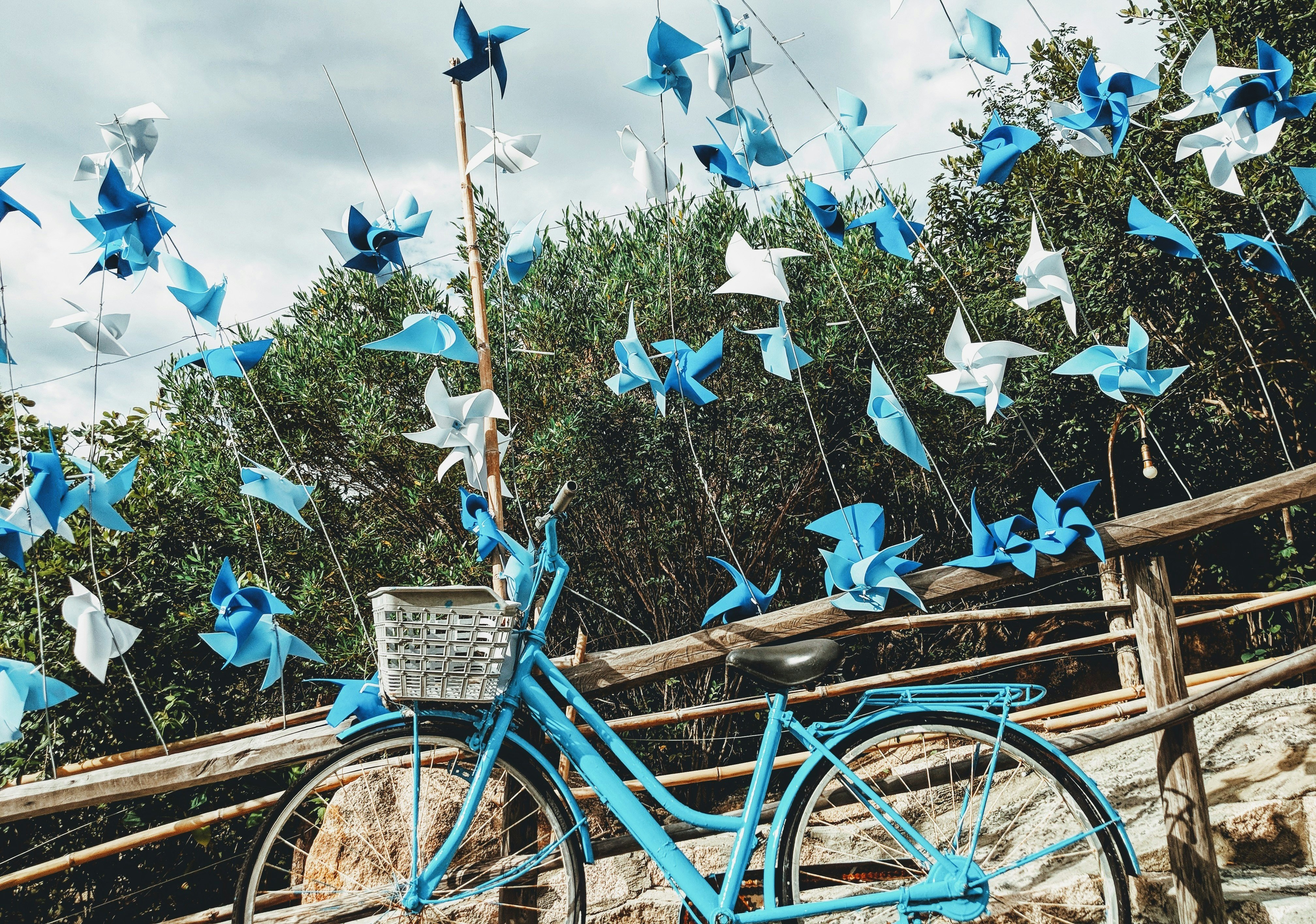 blue bicycle beside brown wooden fence during daytime