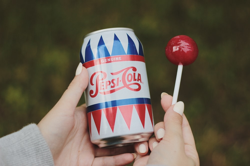 person holding Pepsi-Cola soda bottle