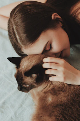 Mujer acariciando a su gato marrón