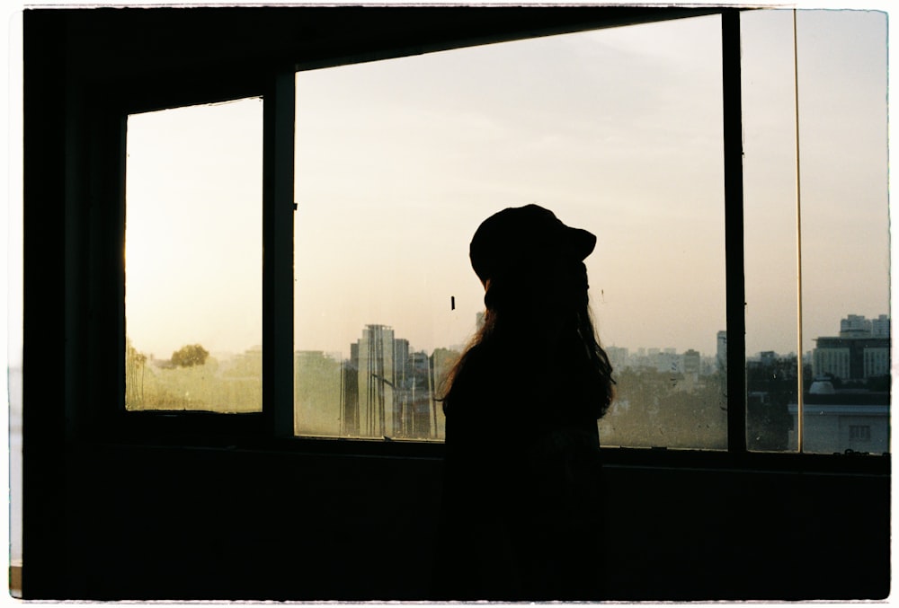 silhouette of woman near window