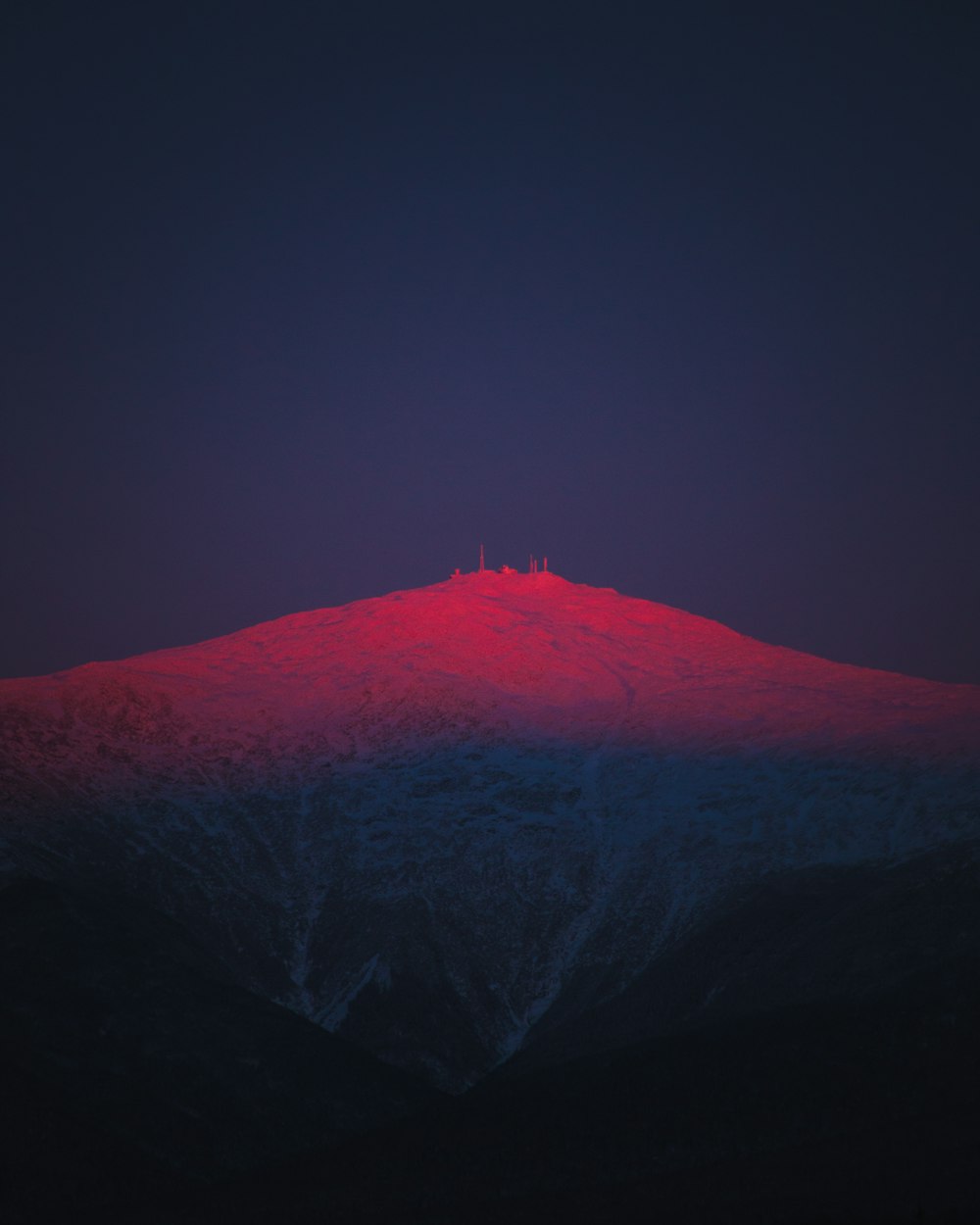 Una montaña con una luz roja en la parte superior