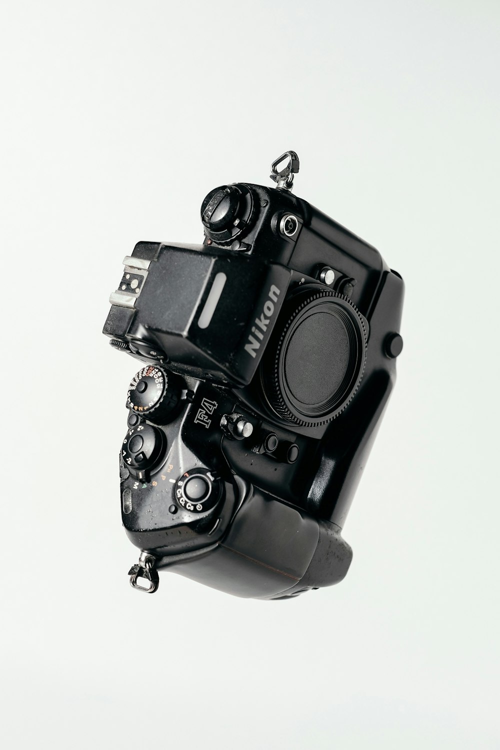 black Nikon DSLR camera on whit surface
