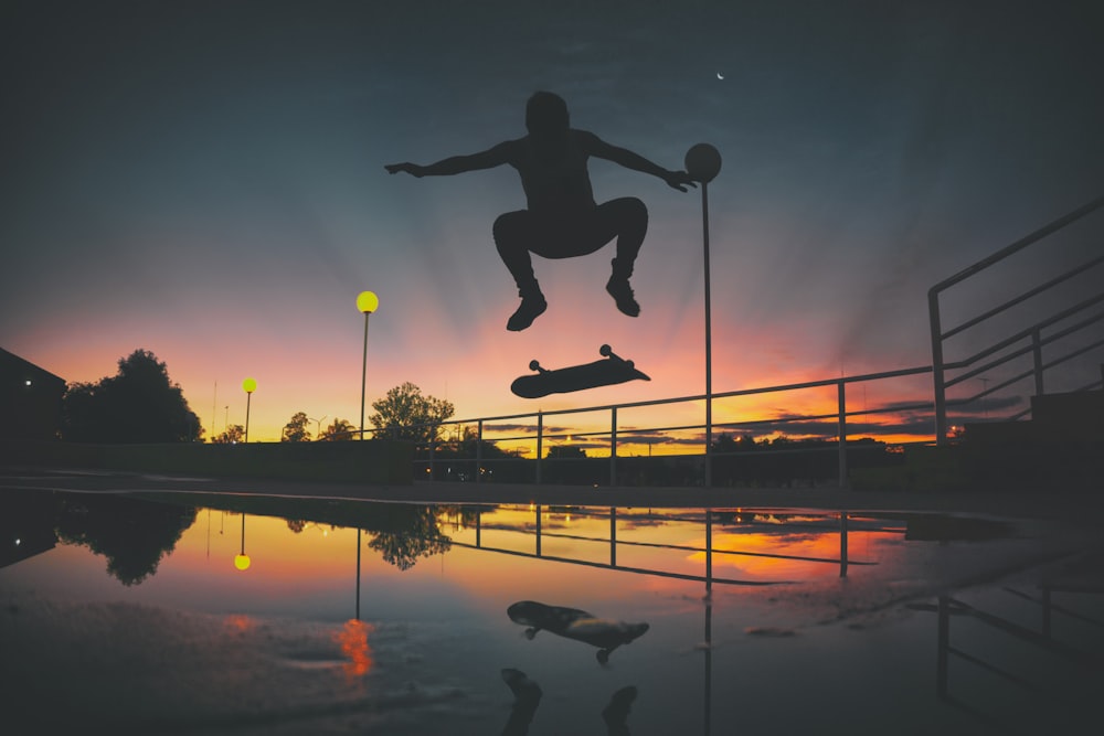 Silhouette eines Skateboard-Spielers, der eine Ausstellung im Park macht