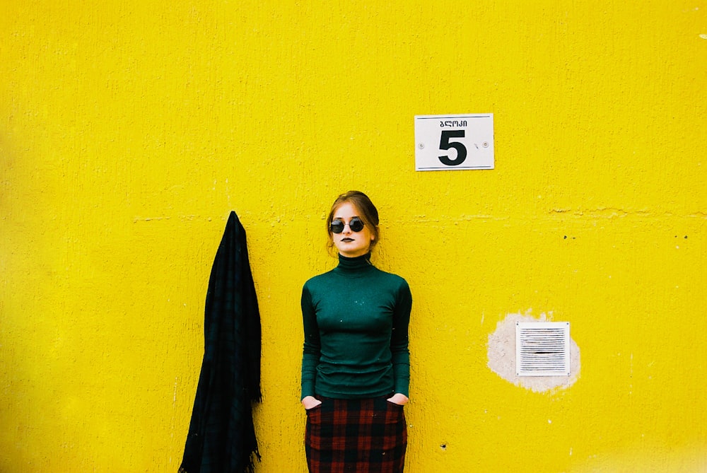 woman standing on front of yellow wall